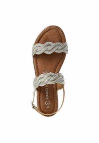 Sandale en cuir marron avec des sangles argentées tressées et des accents décoratifs. Design ouvert avec une sangle de cheville ajustable. Semelle plate.