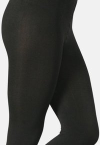 Leggings neri con un tessuto liscio ed elastico e un design aderente. La costruzione senza cuciture migliora comfort e flessibilità, ideale per l'abbigliamento sportivo.