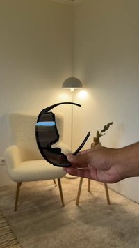 Mustat aurinkolasit, joissa on kaareva, ympäröivä muotoilu. Valmistettu kevyestä muovista, joissa tummennetut linssit ja sirot, ohuet sankat.