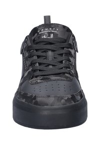 Zwarte sneaker met een gestructureerd camouflagepatroon, voorzien van een ronde neus, platte veters en een dikke rubberen zool met perforaties op de bovenkant.