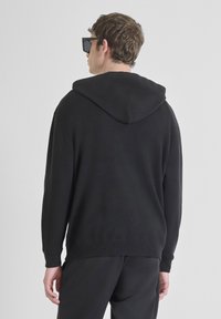 Felpa nera con una vestibilità comoda, dotata di cappuccio con coulisse e polsini a costine. Tessuto morbido e design semplice senza loghi visibili.