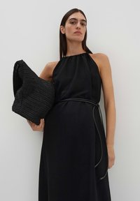 Abito nero con scollatura a halter, dalla vestibilità aderente, orlo testurizzato e borsa nera intrecciata, caratterizzata da una sensazione morbida e elementi di design minimalisti.