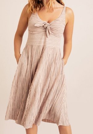 Robe midi rayée rose clair avec un détail de nœud à l'avant, des bretelles fines et des poches latérales, présentant une texture de jupe plissée.