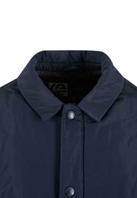 Marineblaue Jacke mit glatter Textur, klassischem Kragen und einer Vorderseite mit schwarzem Druckknopfverschluss. Intern sichtbares Logo.