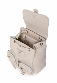 Jasno beżowy plecak z klapką na górze, srebrnymi akcentami, z zamknięciem na sznurek oraz dwoma zasuwanymi kieszeniami z przodu. Gładka tekstura, minimalistyczny design.