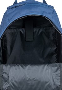 Intérieur d'un sac à dos bleu avec un revêtement noir doux, une sangle centrale réglable et un tissu lisse sans poches visibles.