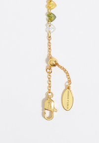 Cadena de oro con acentos de cuentas de vidrio multicolores. Presenta un cierre de langosta y una etiqueta grabada con "BIMBA Y LOLA". Textura suave en toda su extensión.
