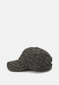 Gorra negra con un diseño texturizado, visera curvada y correa ajustable en la parte trasera, con formas ovaladas repetidas en tonos oscuros.