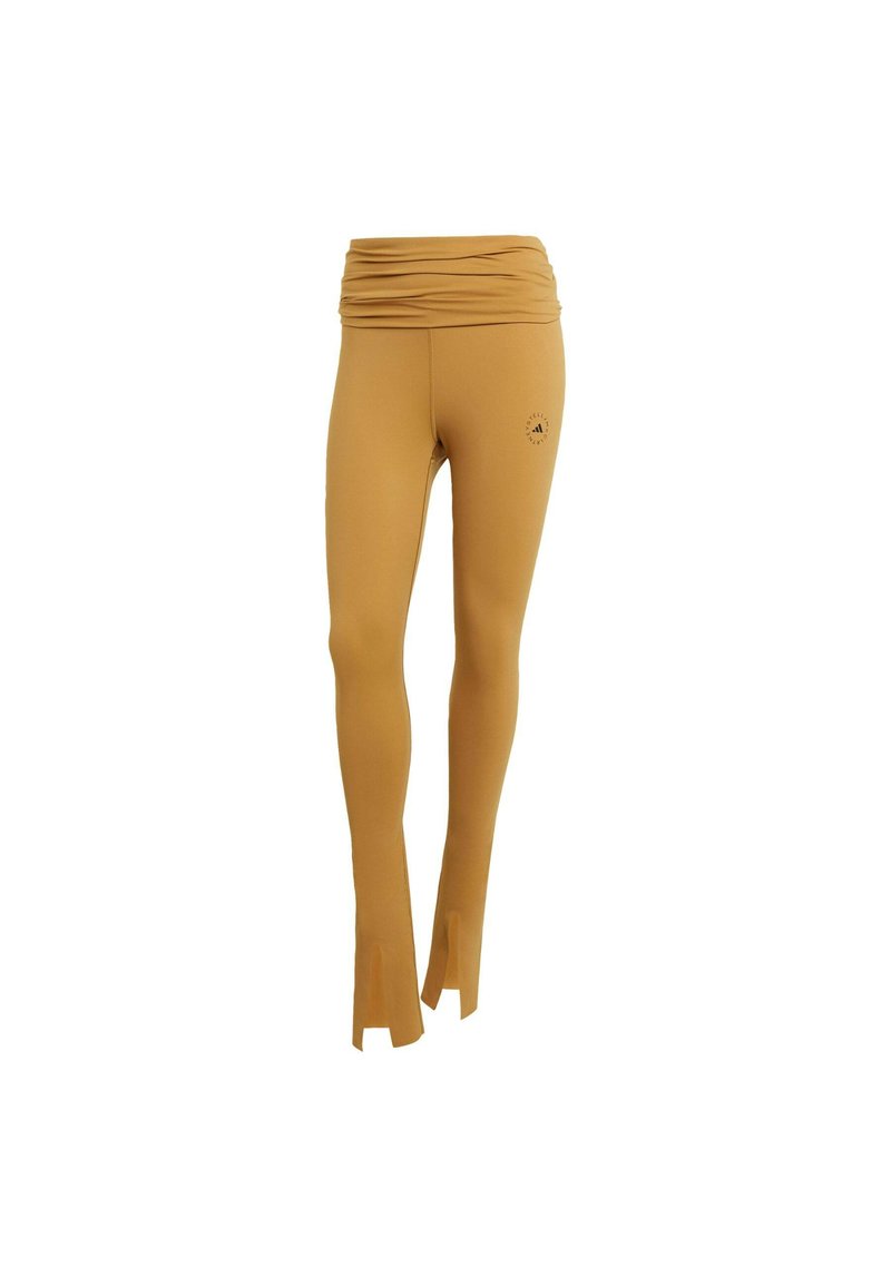 Mosterdkleurige legging met een gerimpelde tailleband, uitlopende zoom en logodetail aan de zijkant, gemaakt van rekbaar, glad materiaal.