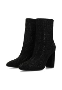 Bottes noires à la cheville en suède doux avec une surface texturée, présentant un bout pointu et un talon épais orné de petits clous.