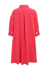 Robe coral longue et lumineuse avec un col, des manches froncées jusqu'au coude et un pli central à l'arrière. Tissu lisse avec un design fluide.