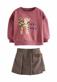 Sudadera rosa con un gráfico de leopardo y texto azul, combinada con una falda marrón con un estampado y detalle de hebilla lateral.