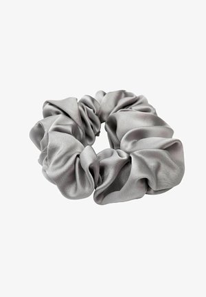 Scrunchie grigio in raso con pieghe di tessuto morbide e raccolte e un elastico circolare per acconciare i capelli.