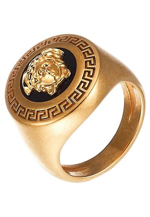 Bague à cachet en or avec un centre noir présentant une tête de lion en relief et un motif géométrique de clé grecque autour du bord.