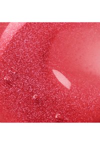 Close-up of a smooth, shiny red surface with fine glitter and small air bubbles visible under the gloss.