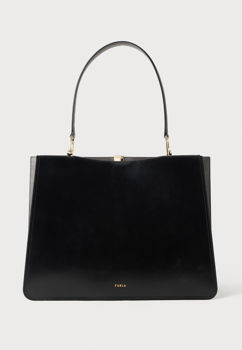 Saco tote preto em couro com textura suave, apresentando uma alça superior única e um detalhe em metal dourado. Nome da marca visível na frente.