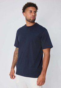 T-shirt en coton bleu marine à manches courtes et col rond, avec un design simple uni et une coupe décontractée. Aucun motif visible.