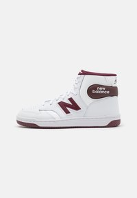High-top sneakers in white leather with maroon accents, featuring perforated toe, padded collar, and a prominent 'N' logo on the side.