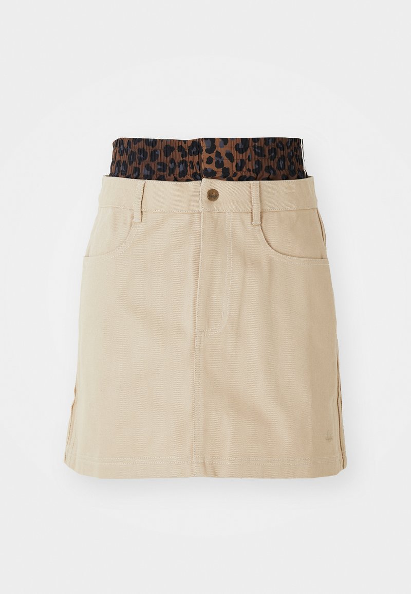 Tan denim rok met een bruine elastieken tailleband met luipaardprint, voorzakken en een rechte snit, met zichtbare stikdetails.