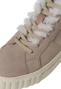 Mockasinsneaker i ljusbeige med en strukturerad yta. Har beige snören, en fluffig vit krage och en räfflad off-white sula.