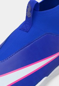 Μπλε σνίκερ χωρίς κορδόνια με υφή στο επάνω μέρος, θήκη για το χέρι, και άσπρες και ροζ λεπτομέρειες στο πλάι. Ενισχυμένες ραφές.