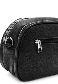 Bolso de cuero texturizado negro con forma redondeada, que presenta herrajes plateados, doble cremallera en la parte superior y un bolsillo con cremallera en el lateral.