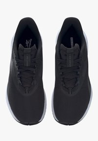 Zapatillas deportivas negras con parte superior de malla texturizada, punta redondeada y suela de goma blanca. Presenta cordones y una marca en la plantilla.