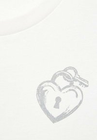 T-shirt en coton blanc avec un design en forme de cadenas en cœur argenté, accompagné d'une clé, présentant une clé visible et une texture lisse.