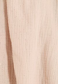 Tela de color rosa claro con un tejido texturizado, que presenta sutiles destellos brillantes a lo largo, creando una apariencia delicada y suave.