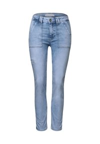 Jean en denim bleu clair avec une coupe slim, présentant des poches avant à patte, une fermeture éclair et des détails légèrement déchirés sur une jambe.