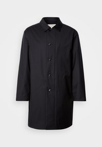 Μαύρο παλτό με κουμπιά μπροστά, γιακά με αιχμές και μακριά μανίκια. Κατασκευασμένο από λείο ύφασμα, διαθέτει έξι κουμπιά και ίσια κοπή.