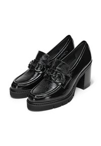 Schwarze lacklederne Slipper mit einem klobigen Blockabsatz, ausgestattet mit einem dekorativen Riemen mit Kettenakzenten und einer strukturierten Oberfläche.