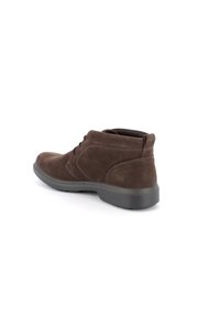 Stivali ankle in suede marrone con punta rotonda, design con lacci, cuciture a contrasto e suola in gomma. Il tacco è alto circa 1 pollice.