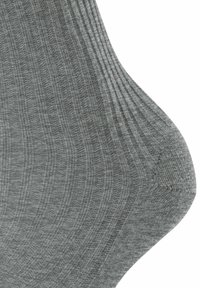 Calzino grigio a coste con una texture liscia. Presenta sottili linee orizzontali e un rinforzo nella zona del tallone e della punta.