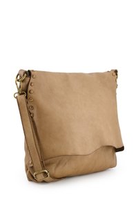 Tan leren handtas met een gladde textuur, een vouwontwerp, messingen studs langs de rand en een verstelbare schouderband.