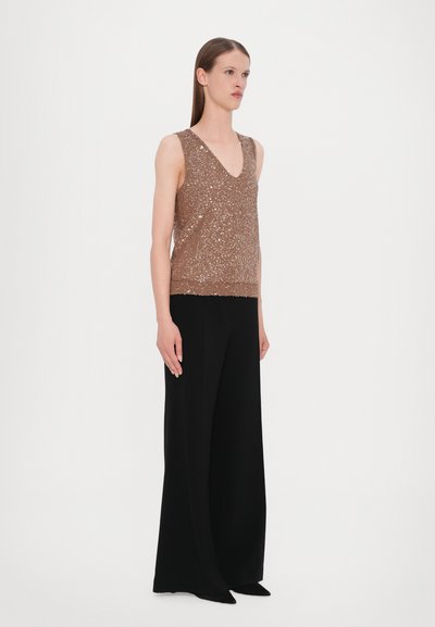 Débardeur en sequins bronze avec un décolleté en V et sans manches, associé à un pantalon large noir. Texture lisse, accents scintillants.