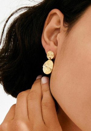 Kuldsed spiraalkõrvarõngad tekstuurse ja kihilise disainiga. Ringikujulised vormid poleeritud viimistlusega, ripuvad väikese naelaga kinnituse küljes.