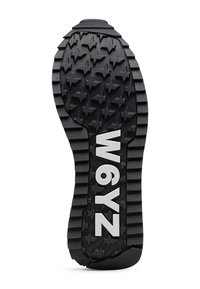 Schwarze Gummisohle mit strukturiertem Sternenmuster, horizontalen Rillen und weißem "W6YZ" Branding. Robustes Design für optimale Traktion.