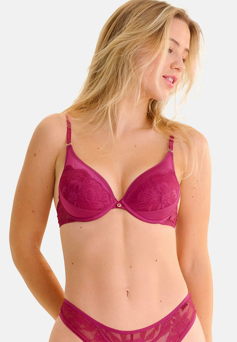 Mauve kant-bh met gepolsterde cups, verstelbare banden en bloemenmotieven. Heeft een klein gouden accent in het midden. Soepele textuur.