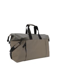 Bolsa de deporte hecha de material duradero y resistente al agua en beige y gris, con correas negras, una parte superior con cremallera y un bolsillo frontal.