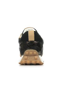 Baskets de sport en mesh noir avec un accent texturé doré au talon, dotées d'une semelle en caoutchouc avec des crampons proéminents pour l'adhérence.