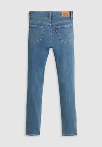 Jeans de mezclilla azul con un corte ajustado. Presenta un parche de cuero marrón en la cintura y dos bolsillos traseros con un diseño de costura distintivo.
