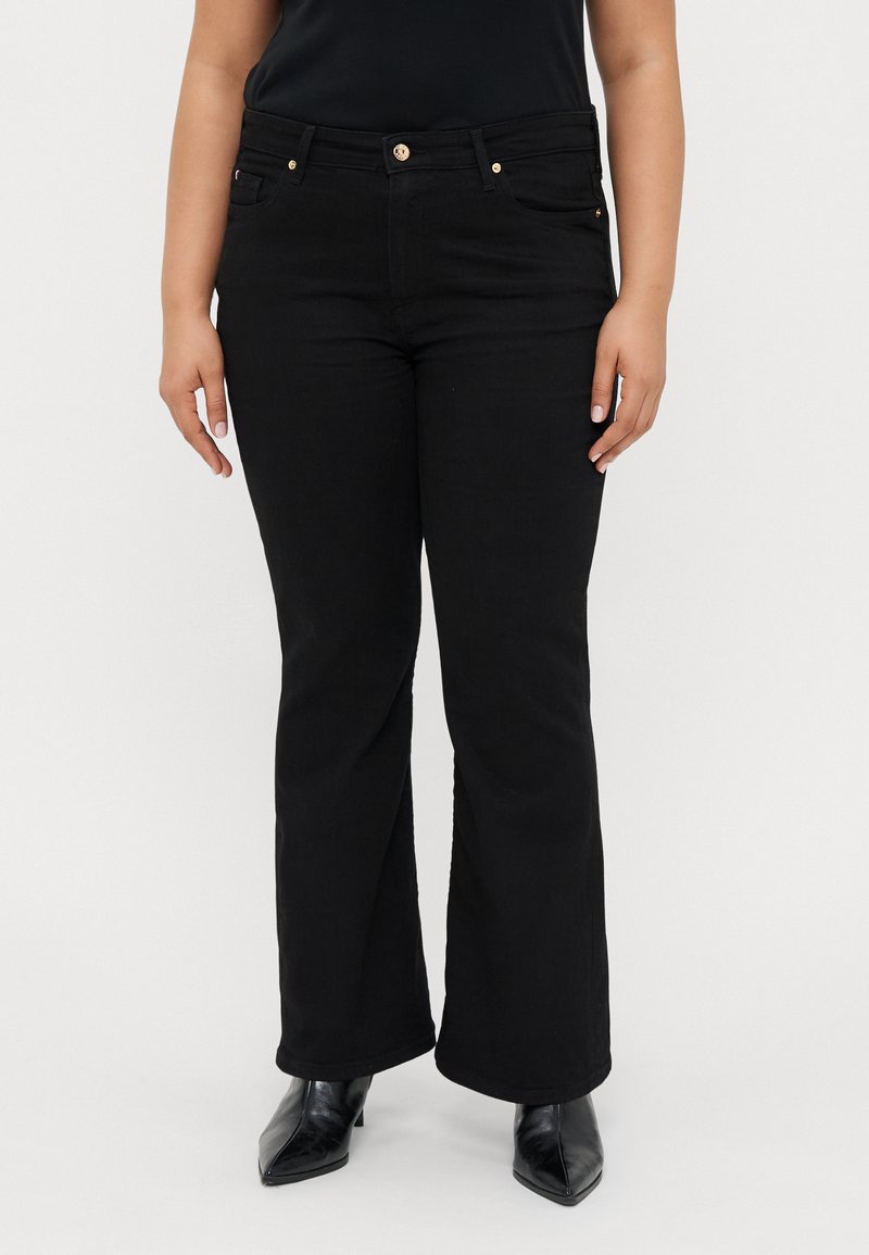 Jean évasé noir avec une taille mi-haute, comportant deux poches avant, des boutons dorés et un tissu lisse, légèrement texturé.