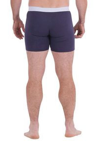 Boxer-briefs bleu marine avec une ceinture élastique blanche, présentant un design ajusté et une texture de tissu lisse, montrant la vue de dos.