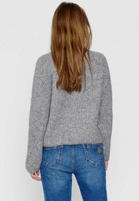 Grijze gebreide trui met een gestructureerd patroon, ronde halslijn en lang mouwen, gecombineerd met blauwe jeans met een klassieke zakontwerp.