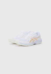 Hvide sportssko lavet af mesh og syntetisk materiale, med en beige logo og detaljer, rund tå og tekstureret gummisål.