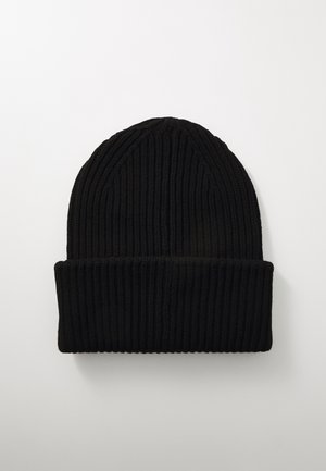 Bonnet en tricot noir avec une texture côtelée, présentant un revers plié. Le design est simple et fonctionnel, adapté au port par temps froid.