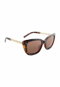 Teknőspajzs mintás napszemüveg barna lencsékkel, nagy méretű macskaszem formával és aranylánc díszítéssel a száraknál. Simított műanyag textúra.