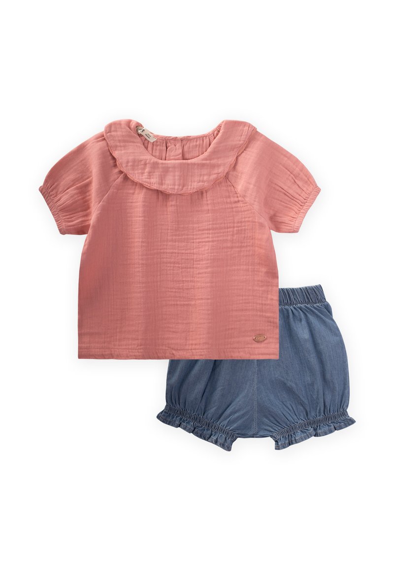 Blusa di cotone rosa con collarino arricciato e maniche corte, abbinata a pantaloni corti in denim con vita elastica e orlo arricciato.