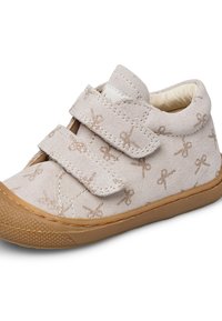Světle béžová semišová botička pro batole s hnědou gumovou podrážkou, třpytivými vzory mašliček a se dvěma suchými zipy na zapínání.
